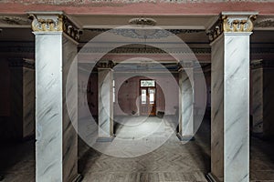 Large entrance hall with columns in old abandoned mansion