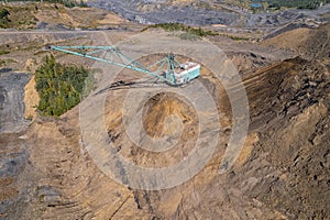 Large excavator removes overburden from soil to extract coal, Aerial drone top view