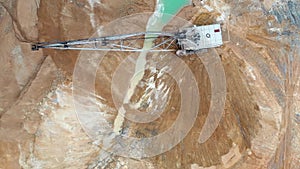 A large excavator works in the quarry. Drone view.