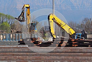 Large excavators with  grapples while  they grabbing industrial ferrous material scrap