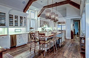 Large expensive chefs kitchen in luxury home with rough hewn wood and white cabinets