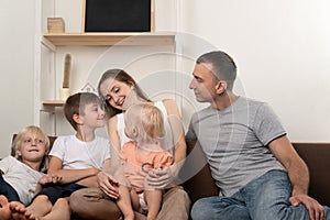 Large family mother father, two sons and little daughter are chatting on couch. Family leisure