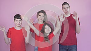 Large family of sons and a daughter. They look at the camera, wave their hand