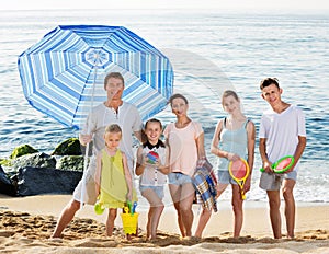 Large family standing together on beach on summer day