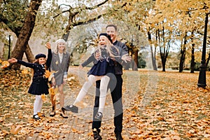 A large family walks in the park in the fall. Happy people in the autumn park