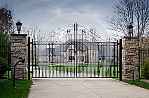 Large fancy mansion behind a gated entry photo