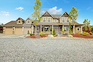 Large farm country house with gravel driveway and green landscape.