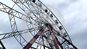 Large Ferris wheel close-up against a gray cloudy sky