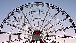 Large Ferris wheel with illumination, against the sky, sunset, twilight.