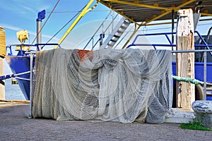 Large fishing nets stored over railing of fishing boat