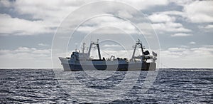 Large fishing trawler conducts industrial fishing in the open ocean