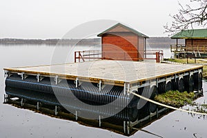 Large floating wooden platforms on pontoons with holiday houses in the lake for leisure and fishing