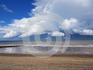Large fluffy clouds over the Hornsea beach East Yorkshire England uk