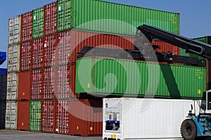 Large forklift stacking containers in port