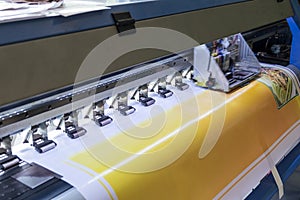 Large format inkjet printer machine working on vinyl paper in workplace
