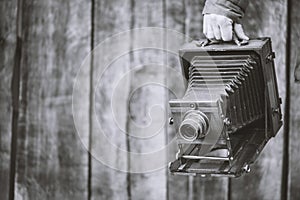 Large format retro camera, 5x7 inches. Photographer holds old studio camera. Monochrome effect, copy space. Concept - photography