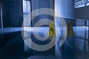 Large format shot of scrubbed marble floor with yellow CAUTION sign