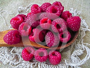 Large fresh red raspberry berries, poured into a wooden spoon