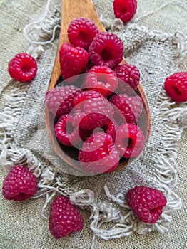 Large fresh red raspberry berries, poured into a wooden spoon