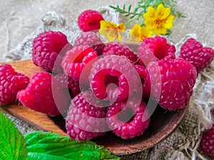 Large fresh red raspberry berries, poured into a wooden spoon