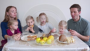 A large and friendly family has lunch at home.