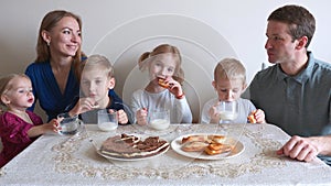 A large and friendly family has lunch at home.