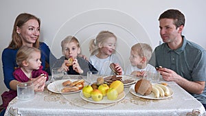 A large and friendly family has lunch at home.