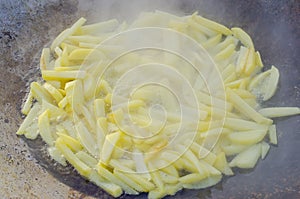 Large frying pan with potatoes in nature in winter