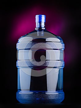 Large gallon of water on black background with pink tints