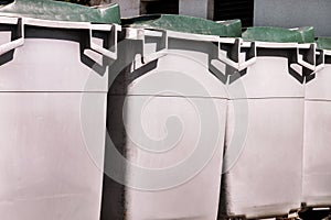 Large garbage containers, trash dumpsters and bins standing in row. Orderly stowed garbage cans. photo