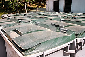 Large garbage containers, trash dumpsters and bins standing in row. Orderly stowed garbage cans ready for separate garbage.