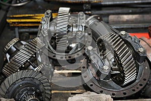 Large gears of a truck. The engine and shaft with gears are disassembled. Black, metal engine parts
