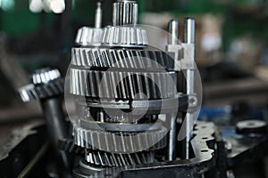 Large gears of a truck. The engine and shaft with gears are disassembled. Black, metal engine parts