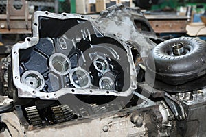 Large gears of a truck. The engine and shaft with gears are disassembled. Black, metal engine parts