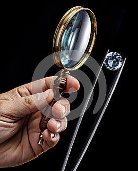 Large gemstone and loupe in jeweler's hands close up. Gem identifying and evaluating process