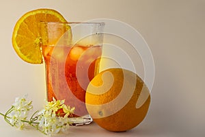 large glass with orange juice and ice a whole orange