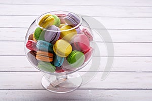Large glass vase full colorful macaroons. Place for the text