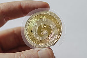 A Large Gold Bitcoin Token in hand