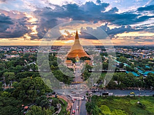 Large golden pagoda Located in the community at sunset , Phra Pa