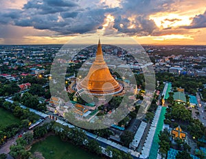 Large golden pagoda Located in the community at sunset , Phra Pa