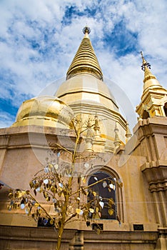 Large golden temple with sky background, Name is Phra Maha Chedi Srivang Chai, Located in Lamphun, Thailand.