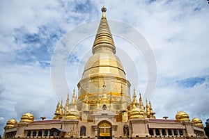 Large golden temple with sky background, Name is Phra Maha Chedi Srivang Chai, Located in Lamphun, Thailand.