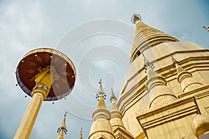 Large golden temple with sky background, Name is Phra Maha Chedi Srivang Chai, Located in Lamphun, Thailand.