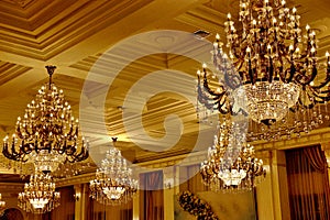 Large Golden vintage crystal chandeliers on the ceiling in the rich hall photo
