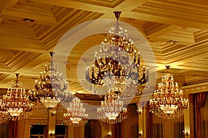 Large Golden vintage crystal chandeliers on the ceiling in the rich hall photo