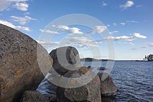 Large granite boulders covered with lichen on the background of the sea