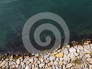 Large granite stones on the river bank. The edge of the river bank, water, road