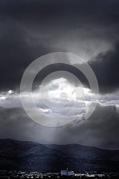 Large Gray Dark Storm Clouds with Sunlight Over Small Town Grain