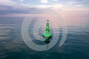 Large green buoy with solar panelsin the sea