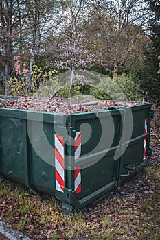 a large green container is completely filled with leaves